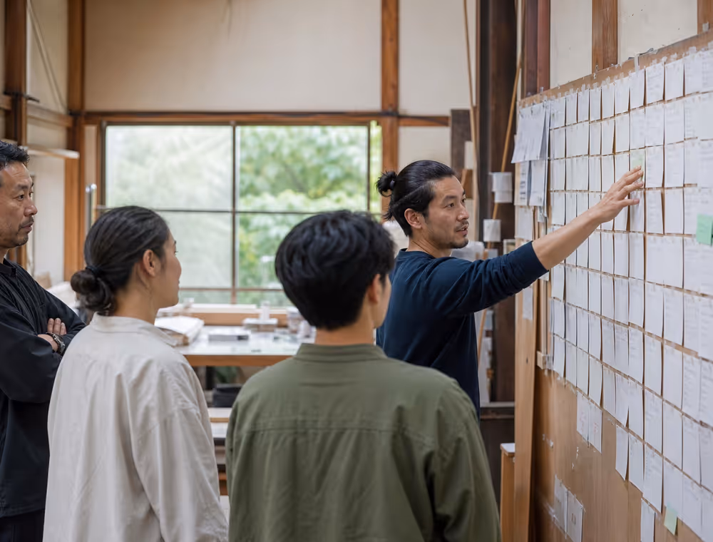 A workshop group reviewing a wall of process cards