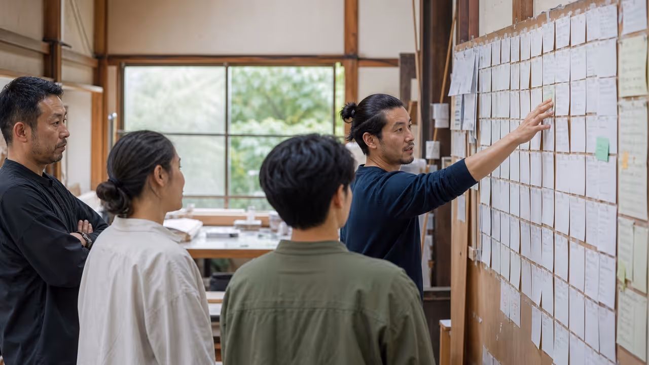 A workshop group reviewing process cards on a wall